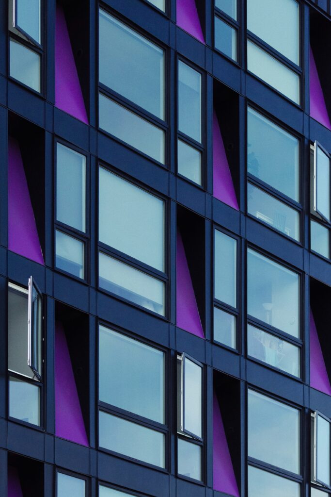 A view of a building and the windows, cladded with ACM panels and purple siding