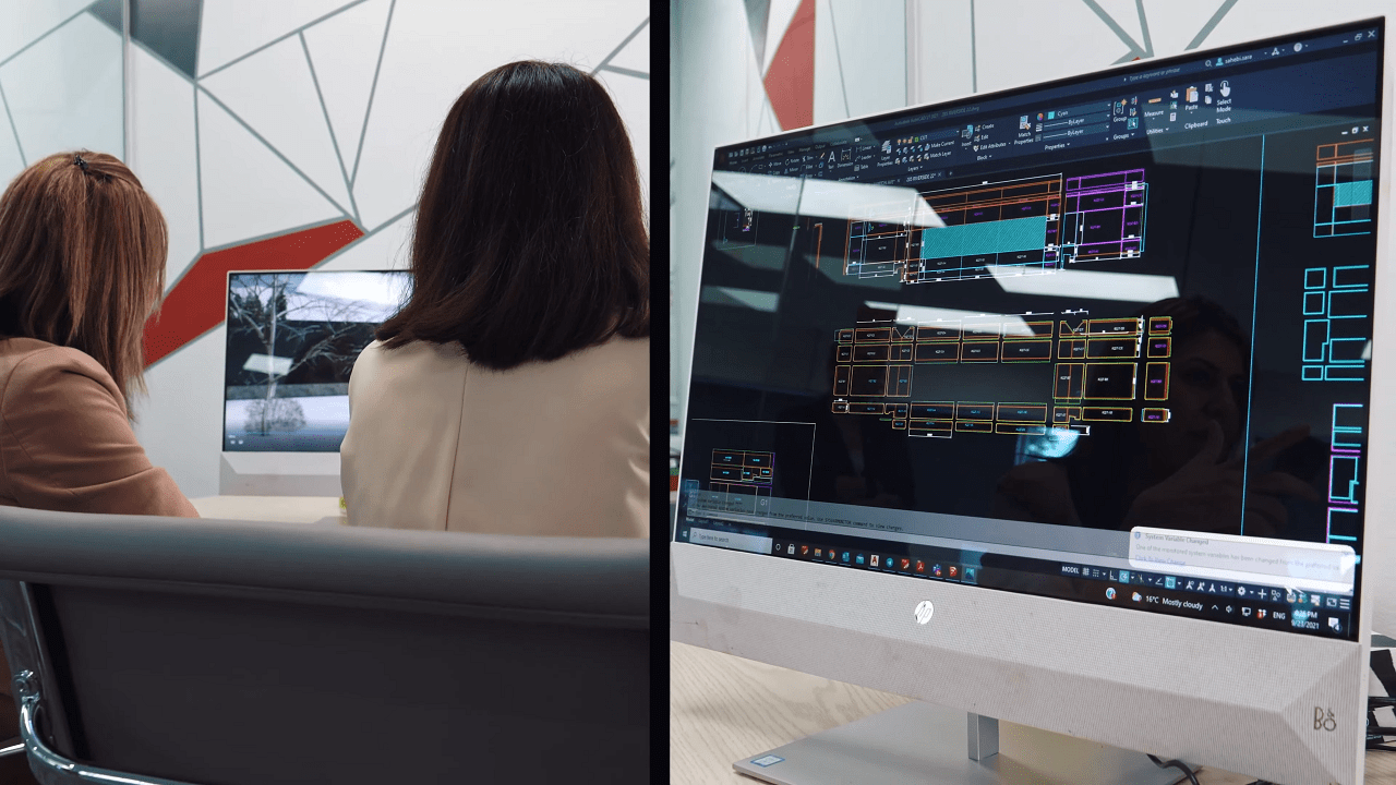 Picture of two wiedehopf's designers lookinf at a computer screen with cladding design on the screen