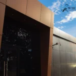 Entrance to a commercial building with brown and black panels.