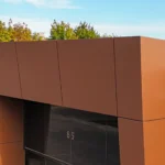 Close-up of a building's roof overhang with brown panels and a light fixture.