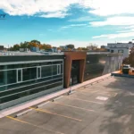 Aerial view of a commercial building and its parking lot from above.