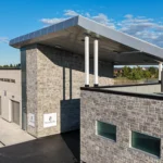 Aerial view of a modern building with a large canopy and gray ACM cladding, part of a Gray ACM Commercial Project.