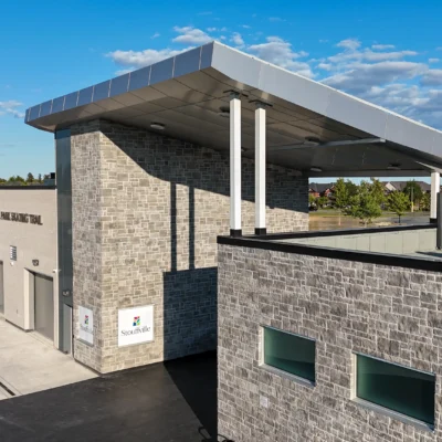 Aerial view of a modern building with a large canopy and gray ACM cladding, part of a Gray ACM Commercial Project.