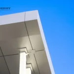 Close-up of a structural column supporting a gray ACM panel roof canopy.