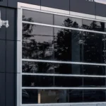A close-up of a black and white commercial building facade with large, reflective windows.