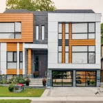Modern home exterior with wood grain aluminum siding accents, dark stone, and glass garage doors.