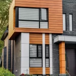 Vertical close-up of the left side of the house showing a box window clad in wood grain aluminum siding.