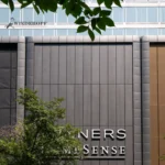 Winners HomeSense store front with dark gray patterned aluminum panels and surrounding structures.