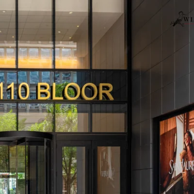 Building entrance with "110 BLOOR" sign and dark gray tile-patterned aluminum panels.