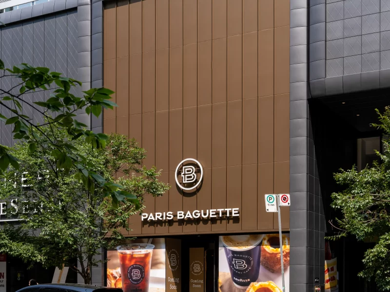 Brown vertical ACM commercial wall panel cladding on a Paris Baguette storefront.