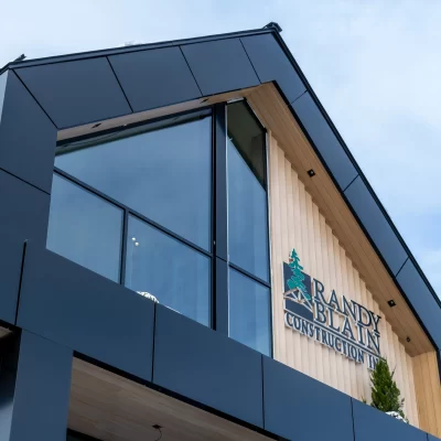Modern building facade with black Aluminum commercial wall panels and large angled glass windows.
