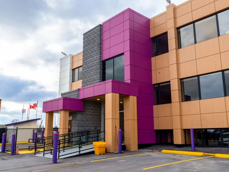 Commercial building exterior featuring pink, beige, and white colorful commercial wall panels.